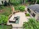 Backyard patio with outdoor fireplace, comfortable seating, and lush landscaping at 10000 Groomsbridge Rd, Johns Creek, GA 30022