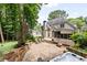 Backyard featuring a stone patio, hot tub, putting green, and mature trees at 10000 Groomsbridge Rd, Johns Creek, GA 30022