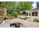 Backyard patio with outdoor fireplace and adjacent screened-in porch at 10000 Groomsbridge Rd, Johns Creek, GA 30022