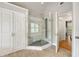 Modern bathroom featuring a glass-enclosed shower, wood look tile floor and access to the rest of the home at 10000 Groomsbridge Rd, Johns Creek, GA 30022