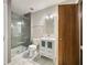 Modern bathroom featuring a glass shower, white vanity, and wood door at 10000 Groomsbridge Rd, Johns Creek, GA 30022