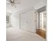Bright bedroom with a ceiling fan, large window, and a doorway to the bathroom offering a comfortable and private space at 10000 Groomsbridge Rd, Johns Creek, GA 30022