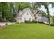 Beautiful home with a large, green front lawn and attached two-car garage in a wooded setting at 10000 Groomsbridge Rd, Johns Creek, GA 30022