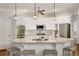 Well-lit kitchen featuring a granite-topped island, white cabinets, stainless steel appliances, and pendant lighting at 10000 Groomsbridge Rd, Johns Creek, GA 30022