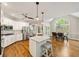 Bright kitchen with stainless appliances, white cabinets, large island, and dining nook with large arched window at 10000 Groomsbridge Rd, Johns Creek, GA 30022