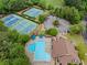Aerial view of the community pool, tennis courts, clubhouse, and parking in a mature landscaped neighborhood at 10000 Groomsbridge Rd, Johns Creek, GA 30022