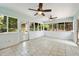 The sunroom features many windows with views of the yard and trees and a neutral tile flooring at 10000 Groomsbridge Rd, Johns Creek, GA 30022
