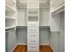 Spacious walk-in closet featuring built-in shelving, drawers, and ample storage space for an organized wardrobe at 10000 Groomsbridge Rd, Johns Creek, GA 30022