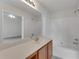 Bathroom with a large mirror, vanity, and shower-tub combo with a white surround at 621 Kenridge Way # 0, Suwanee, GA 30024