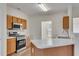 Well-lit kitchen featuring stainless steel appliances, light wood cabinets, and a breakfast bar at 621 Kenridge Way # 0, Suwanee, GA 30024