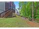 A well-maintained backyard features a fire pit and a wooded view beyond the home's porch and patio at 6217 Millstone Trl, Douglasville, GA 30135