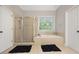 Bright bathroom featuring a separate shower, garden tub, and tile flooring at 6217 Millstone Trl, Douglasville, GA 30135