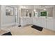 Bright bathroom featuring double sinks, white cabinets, a large mirror, and tile floors at 6217 Millstone Trl, Douglasville, GA 30135