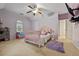 Pink bedroom with ceiling fan, window, and adjoining room at 6217 Millstone Trl, Douglasville, GA 30135