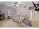 Charming secondary bedroom with light purple walls, a ceiling fan, and carpeted flooring at 6217 Millstone Trl, Douglasville, GA 30135