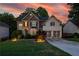 Twilight view of a two-story home with brick and siding under a colorful sky at 6217 Millstone Trl, Douglasville, GA 30135