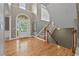 Bright foyer featuring gleaming wood floors, a staircase, and an arched doorway at 6217 Millstone Trl, Douglasville, GA 30135