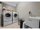 Functional laundry room with modern washer, dryer, utility sink, and storage shelves for convenience at 6217 Millstone Trl, Douglasville, GA 30135