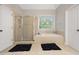 Relaxing main bathroom offers a soaking tub, glass shower, and neutral finishes throughout at 6217 Millstone Trl, Douglasville, GA 30135