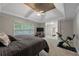 Relaxing main bedroom with tray ceilings, exercise equipment, and an open door to an ensuite bathroom at 6217 Millstone Trl, Douglasville, GA 30135