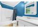 Bathroom with white vanity, vinyl floors, tub, and commode with blue accents at 6650 Bobby John Rd, Atlanta, GA 30349