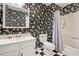 Bathroom with black and white floral wallpaper, black and white tile floors, shower and white vanity at 6650 Bobby John Rd, Atlanta, GA 30349