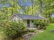 Home in a forest setting featuring a deck, a small backyard garden, and side entry at 6650 Bobby John Rd, Atlanta, GA 30349