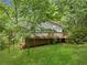 Home exterior featuring a spacious wooden deck, surrounded by lush greenery, on a sunny day at 6650 Bobby John Rd, Atlanta, GA 30349