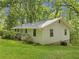 Charming home with white siding, lush green lawn, and mature trees, showcasing a serene setting at 6650 Bobby John Rd, Atlanta, GA 30349