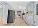 Galley kitchen with white cabinets, modern black appliances, and in unit laundry at 6650 Bobby John Rd, Atlanta, GA 30349