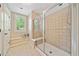 Modern bathroom with a tiled shower, a bench seat, and a window offering natural light and a view of the outdoors at 790 Sienna Dr, Cumming, GA 30040