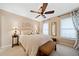 Inviting bedroom with a ceiling fan, neutral walls, and bench seating by the cozy, well-lit sleeping space at 790 Sienna Dr, Cumming, GA 30040