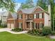 A beautiful brick home shows a manicured green lawn, landscaping, and traditional architectural details at 790 Sienna Dr, Cumming, GA 30040