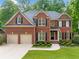 Traditional brick home featuring an attached two-car garage and manicured lawn at 790 Sienna Dr, Cumming, GA 30040