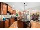 An open kitchen with stainless steel appliances, hardwood floors, black countertops and center island at 790 Sienna Dr, Cumming, GA 30040