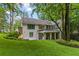Expansive backyard with lush green lawn, mature trees, and a charming white brick home at 1 Habersham Nw Way, Atlanta, GA 30305