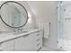Bathroom with marble countertop vanity, round mirror, and a frameless glass shower at 1 Habersham Nw Way, Atlanta, GA 30305