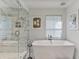 Bright bathroom with glass shower, soaking tub, window with print shade, and unique wall art at 1 Habersham Nw Way, Atlanta, GA 30305
