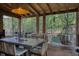 Relaxing covered patio with wood floors and beamed ceiling with seating and dining areas at 1 Habersham Nw Way, Atlanta, GA 30305