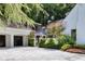 Exterior view of the home featuring a three-car garage, white brick, and mature landscaping at 1 Habersham Nw Way, Atlanta, GA 30305