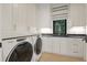 Well-equipped laundry room featuring white cabinets, sink, granite countertops, and a window with blind at 1 Habersham Nw Way, Atlanta, GA 30305