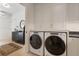 Laundry room with stacked washer/dryer, white cabinets and countertop space; leads to hallway at 1 Habersham Nw Way, Atlanta, GA 30305