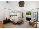 Bright main bedroom with vaulted ceiling, stone fireplace, canopy bed, and ample natural light at 1 Habersham Nw Way, Atlanta, GA 30305