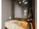 Stylish powder room with amber onyx sink, modern fixtures, and gold trimmed mirror at 1 Habersham Nw Way, Atlanta, GA 30305
