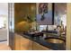 Stylish wet bar featuring a custom sink, dark countertops, and gold accents at 1 Habersham Nw Way, Atlanta, GA 30305