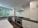 Modern white kitchen with stainless steel appliances, dark countertops and hardwood floors at 1892 Mercedes Ne Ct, Atlanta, GA 30345