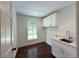 Laundry room with a stainless steel sink, white cabinets, and a view of the front yard at 1892 Mercedes Ne Ct, Atlanta, GA 30345