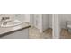 Bright bathroom featuring a double vanity, walk-in shower, and neutral tile flooring at 25 Amberjack Trl, Covington, GA 30016