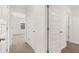 Hallway features multiple doors, neutral walls and carpet, and tile flooring at 25 Amberjack Trl, Covington, GA 30016