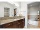Bright bathroom featuring granite counters, dark wood cabinets, and separate tub and shower at 905 Juniper Ne St # 808, Atlanta, GA 30309